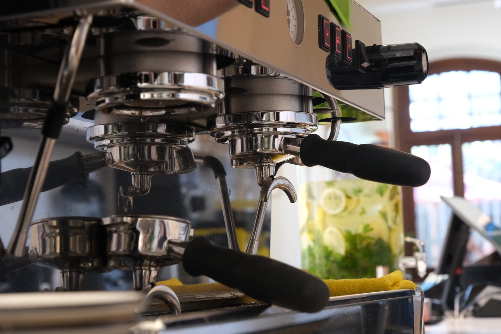 Espresso machine group heads and portafilters behind the bar