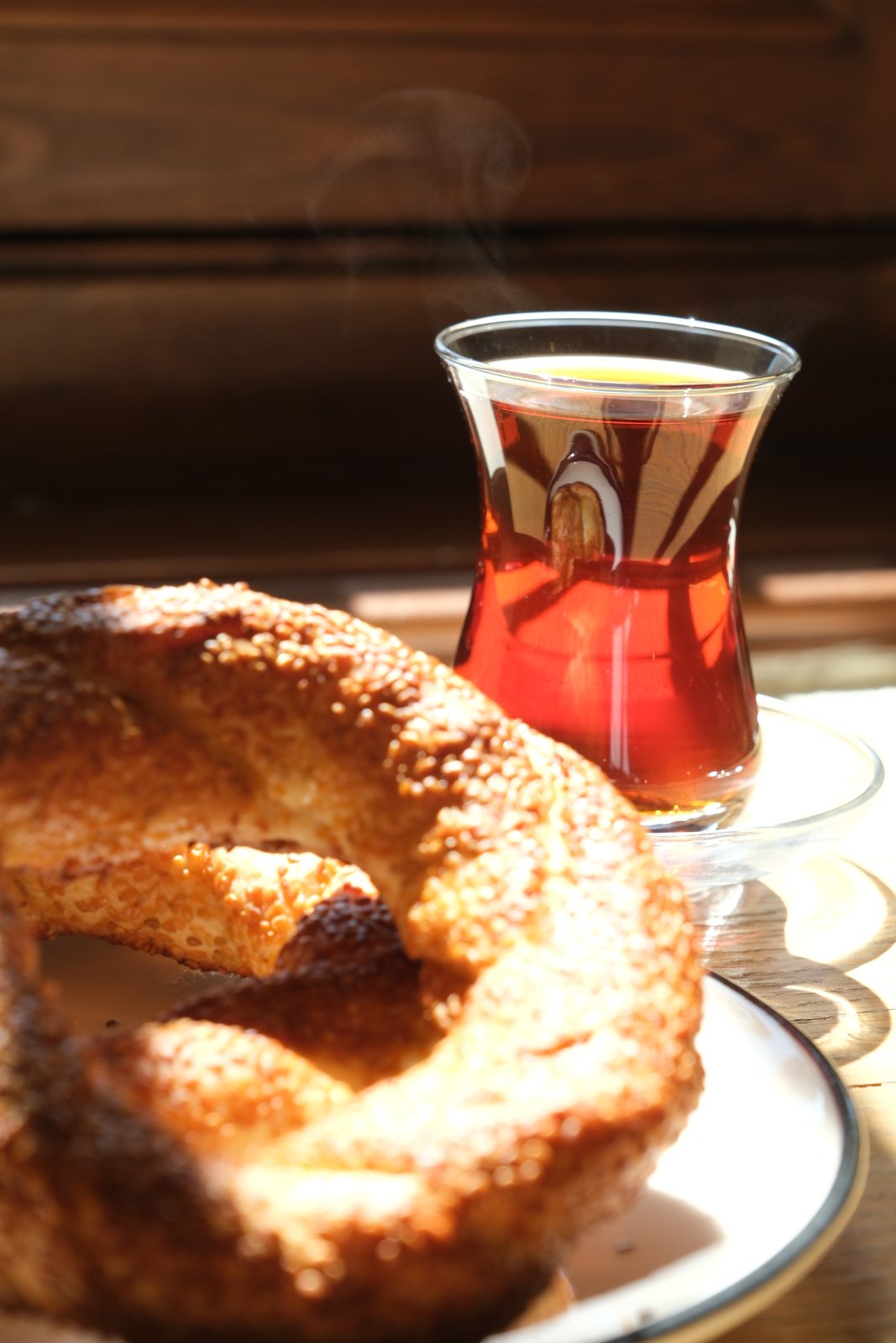 Sesame simit and a glass of Turkish tea in warm window light