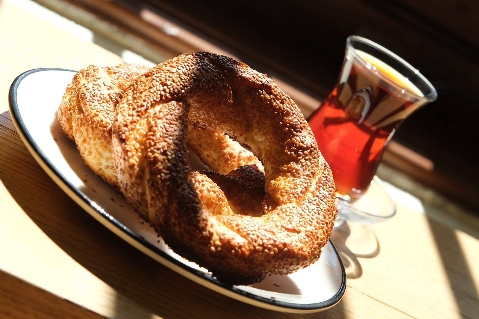 Simit served on a plate with Turkish tea by the window